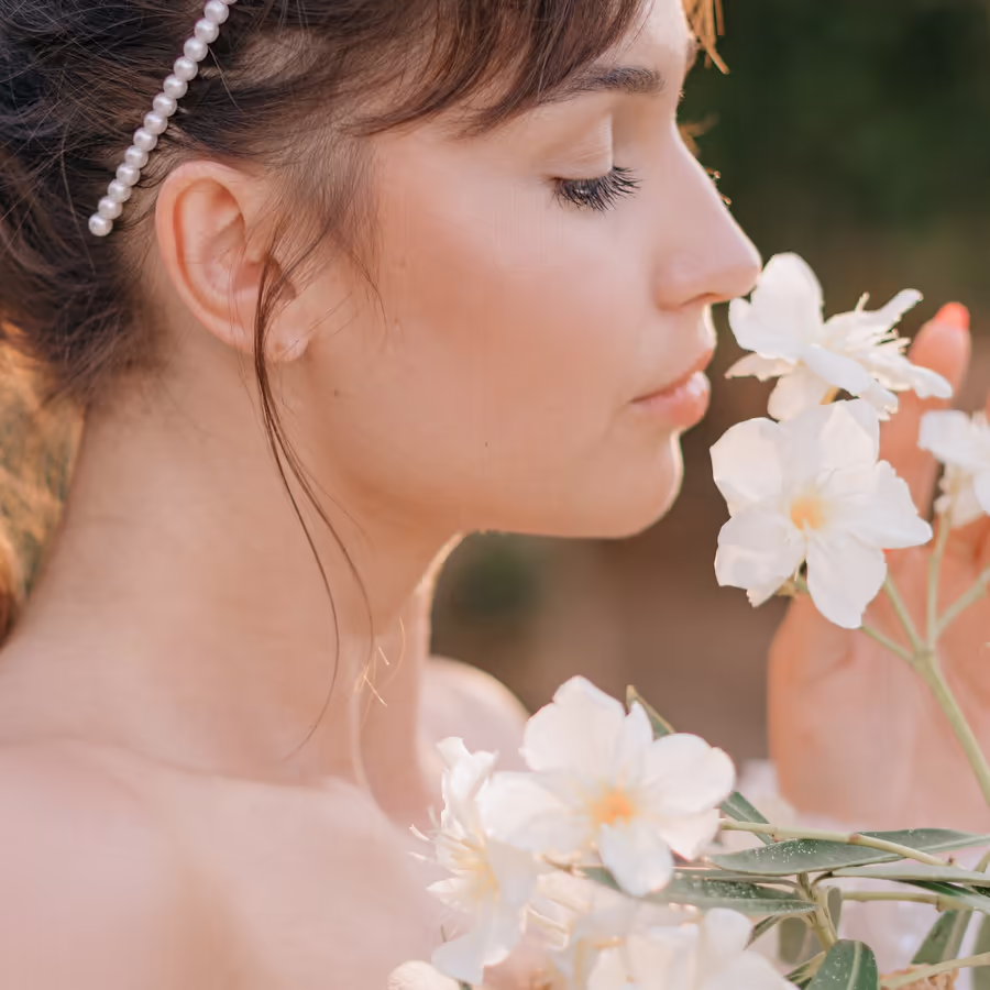 Девушка вдыхает аромат белых цветов
