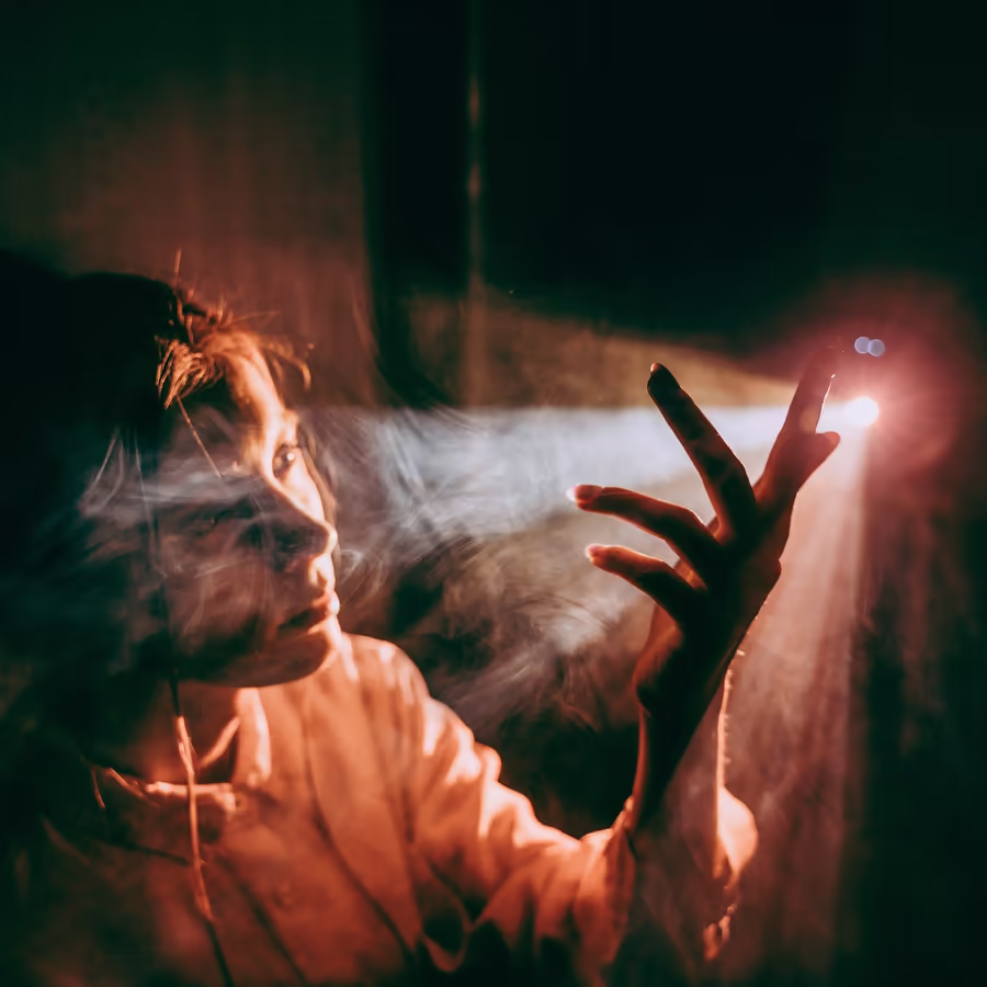 Задумчивый взгляд женщины смотрящей на источник света во мраке