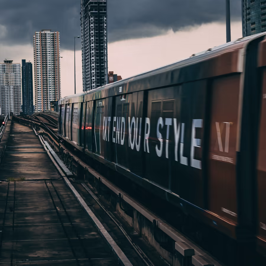 Поезд мчится по рельсам среди небоскребов