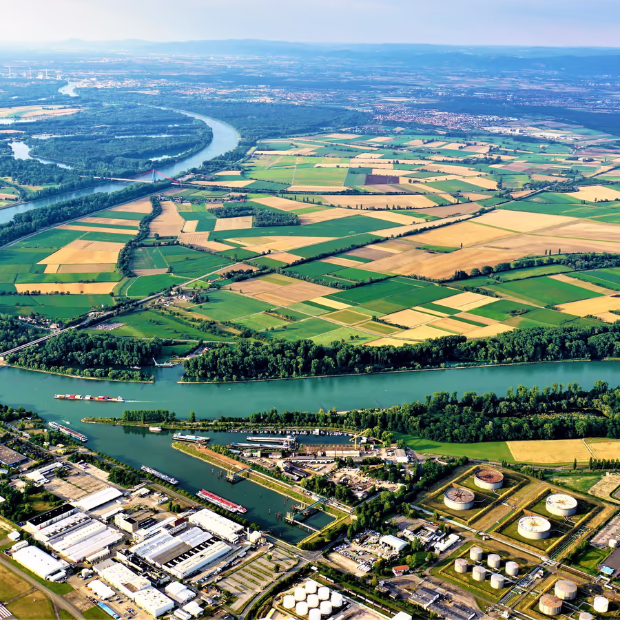 Вид с высоты птичьего полета на реку сельскохозяйственные поля и индустриальную зону