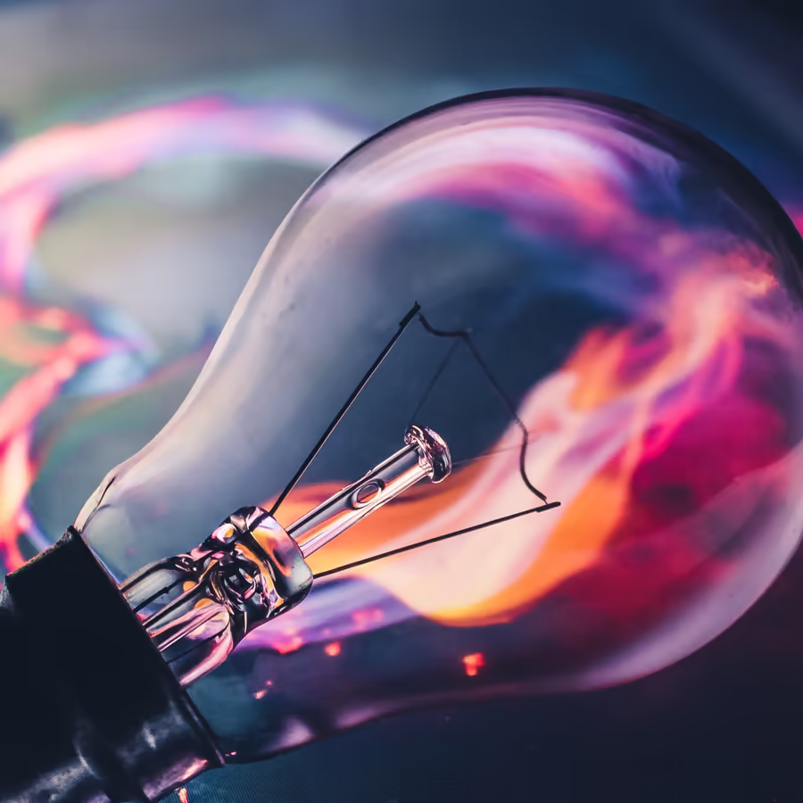 Изображение лампы накаливания внутри которой бушует красочная спираль энергии