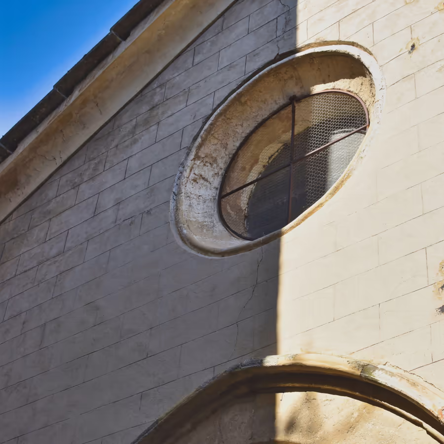 Старинное круглое окно в каменной кладке здания