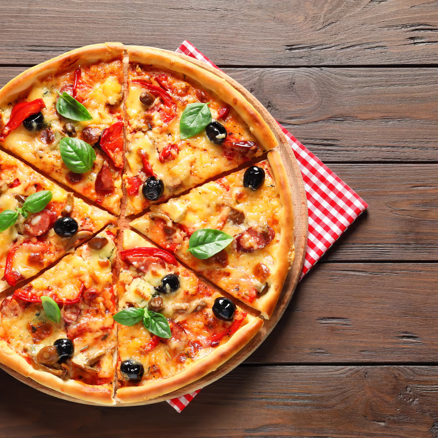 Аппетитная пицца нарезанная на кусочки с колбасой пепперони болгарским перцем и оливками