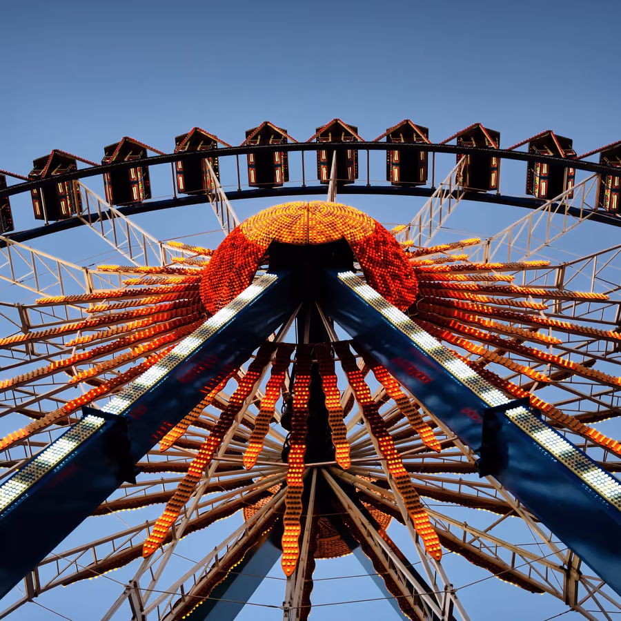 Яркое колесо обозрения в лучах заходящего солнца