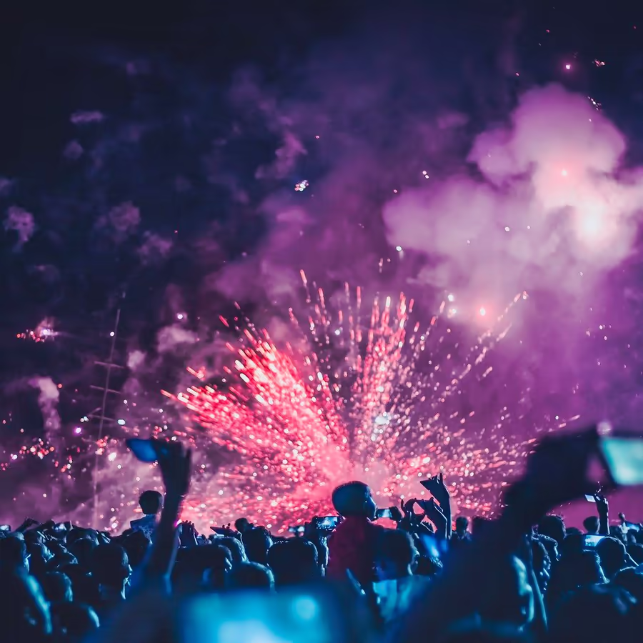 Яркий фиолетовый салют в ночном небе запечатленный во время праздничного мероприятия