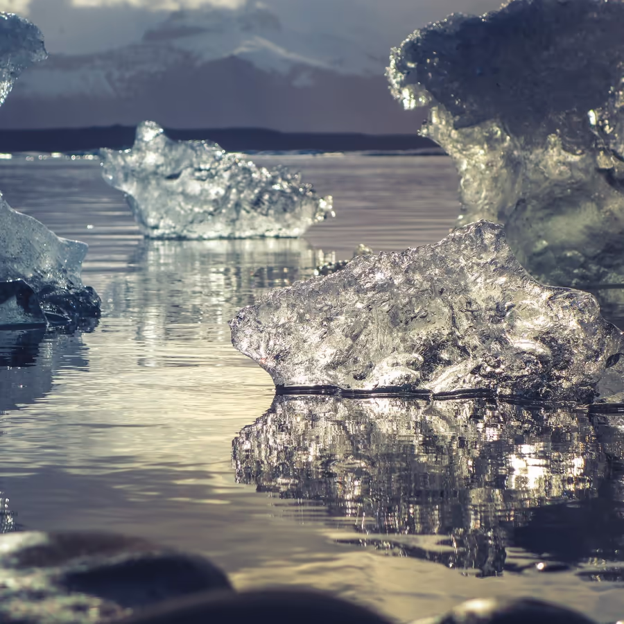 Кристально чистые айсберги дрейфующие в спокойных водах исландской лагуны