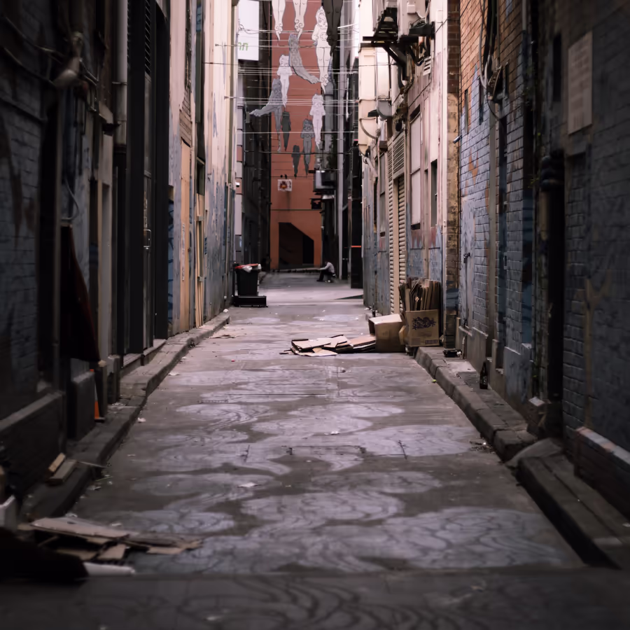 Мрачный городской переулок застроенный кирпичными стенами и исписанный граффити