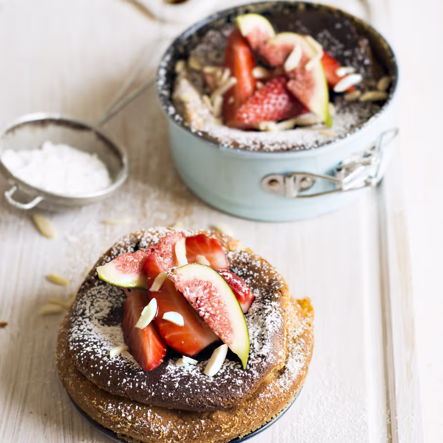 Аппетитный шоколадный десерт украшенный свежими фруктами и миндалем