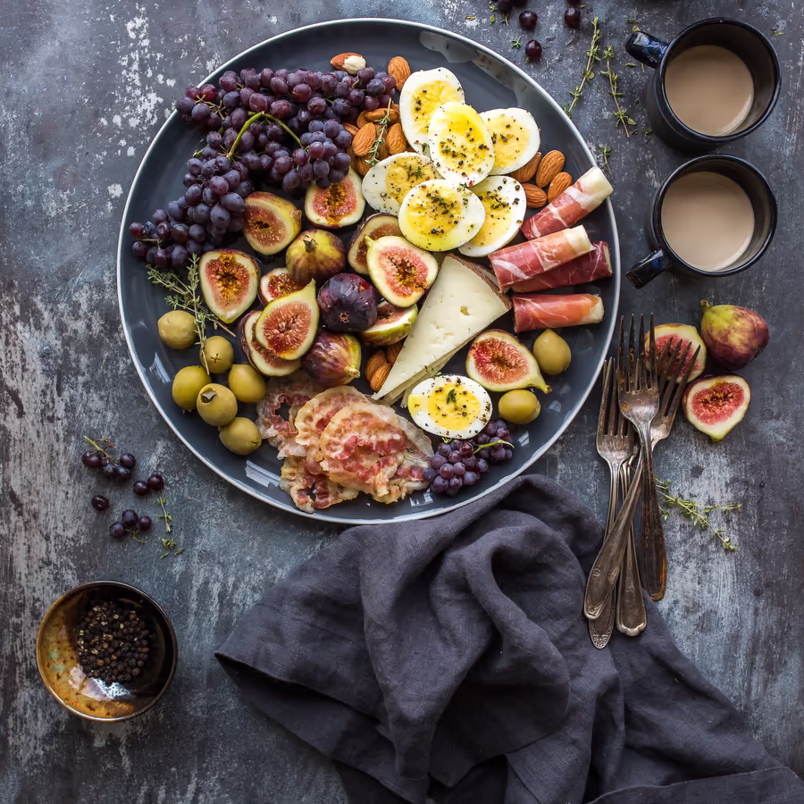 Изысканная сырная тарелка с фруктами мясом и орехами