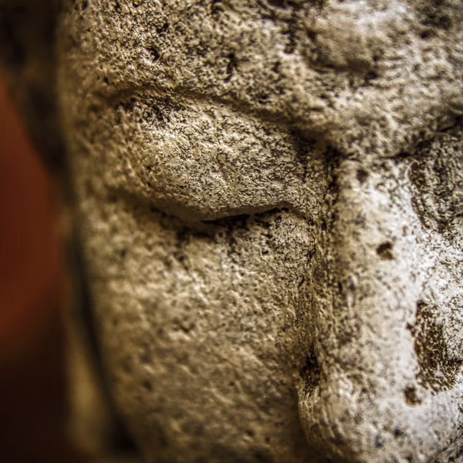 Фрагмент лица каменной статуи демонстрирующий следы времени и эрозии