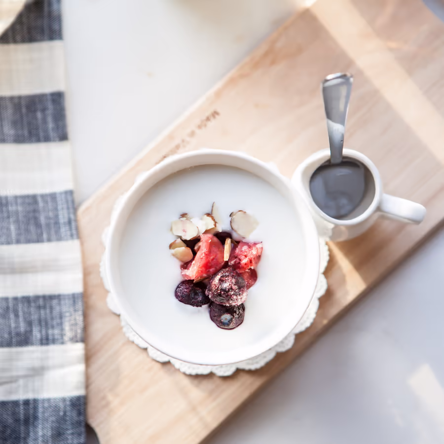 Полезный завтрак или перекус йогурт украшенный свежими ягодами и миндалем