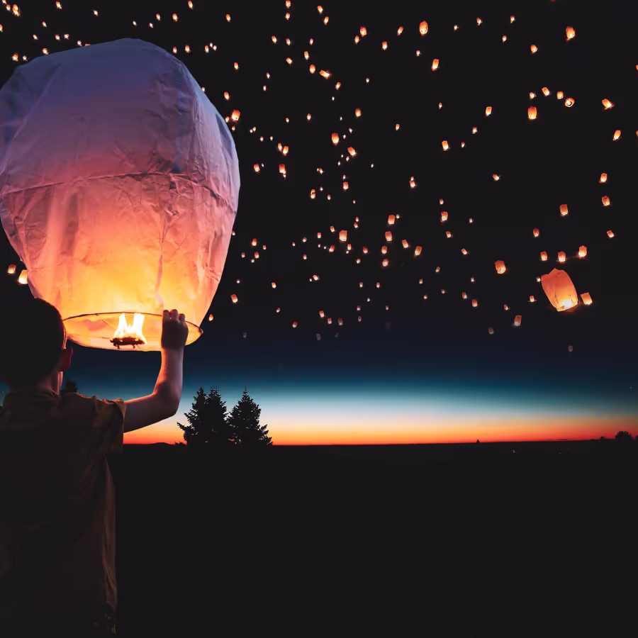 Запуск небесных фонариков на фоне заката