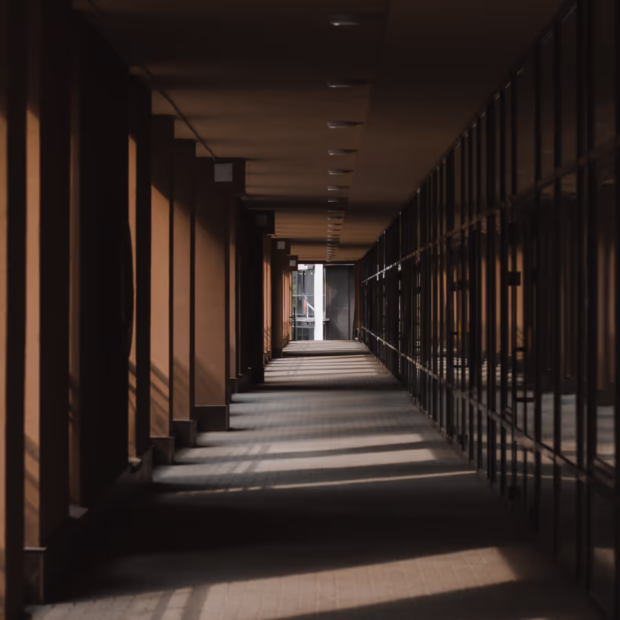 Длинный коридор с рядами окон и приглушенным освещением
