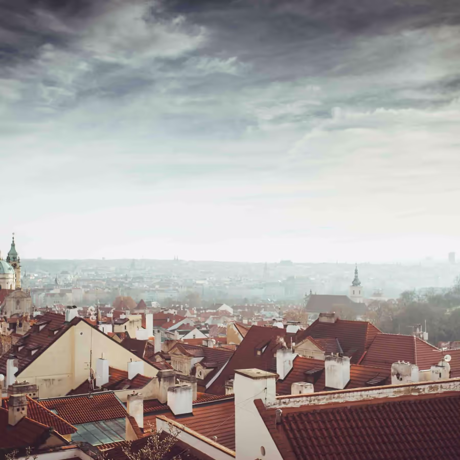 Панорамный вид Праги с черепичными крышами окутанной дымкой