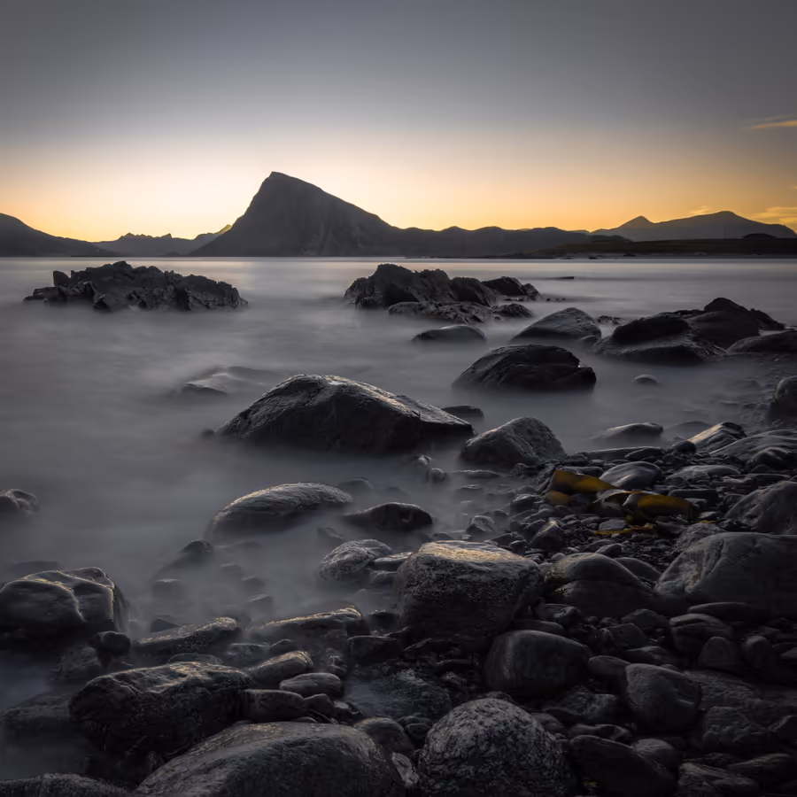 Спокойный пейзаж с закатным небом и каменным побережьем