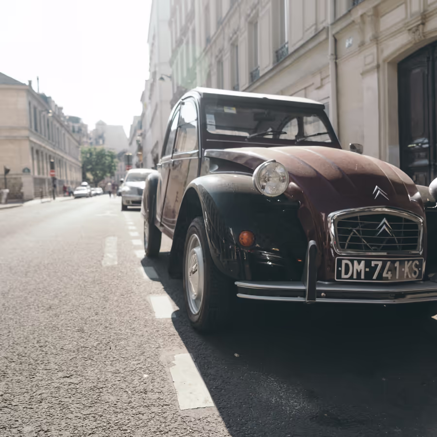 Ржавый Citroën 2CV припаркован вдоль улицы в Париже