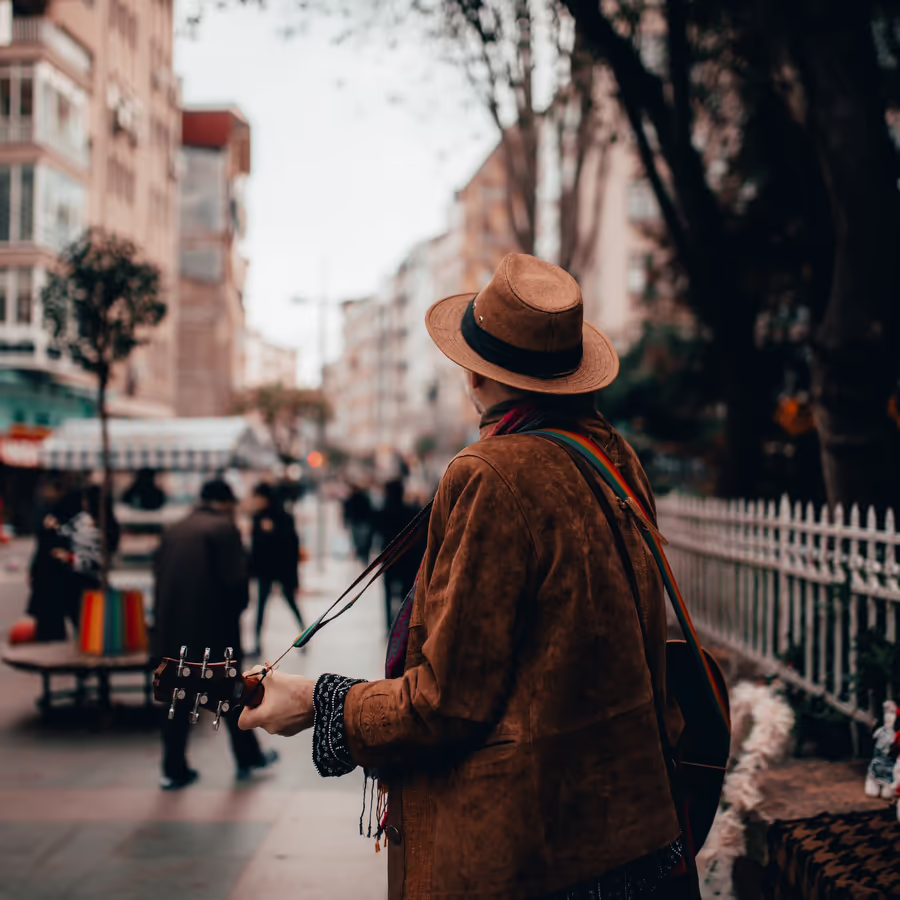 Музыкант с гитарой играет на улице города