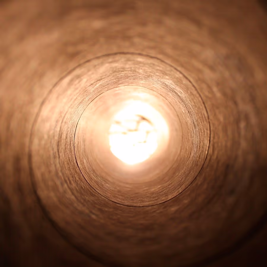 Вид изнутри деревянной трубы на яркий свет