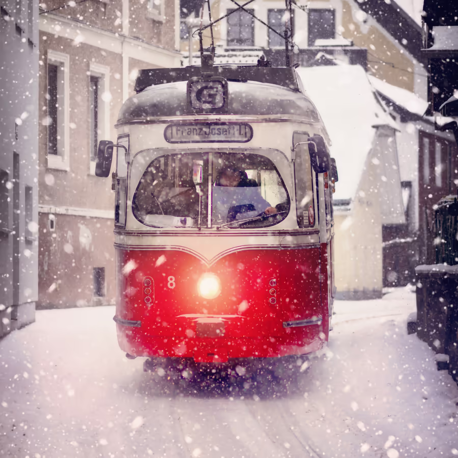 Винтажный красный трамвай едет по заснеженной улице