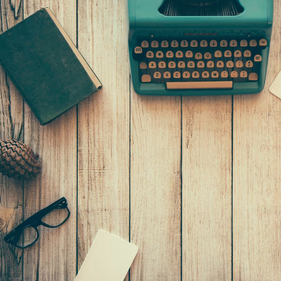 Старинная пишущая машинка книги и очки на деревянном столе